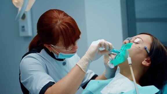 牙科专家在诊所治疗女性牙齿在牙科诊所专业牙医为病人进行口腔注射