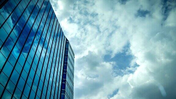 天空与移动的云反射在办公大楼的窗户玻璃上