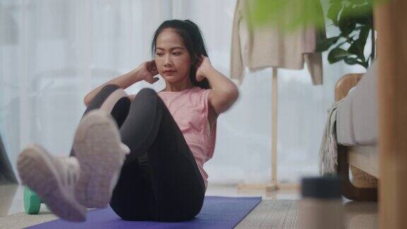 一个有魅力和运动的年轻亚洲女人在家里做运动训练
