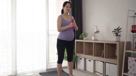 孕妇在客厅举哑铃