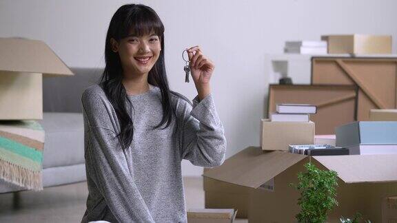 快乐的年轻亚洲女人展示新房子的钥匙