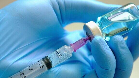医院里医生手里拿着注射器和蓝色的疫苗瓶健康和医学概念