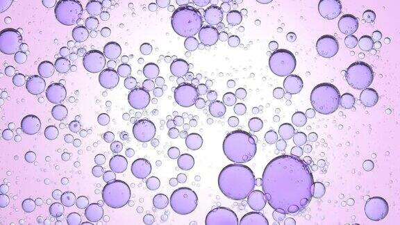 紫色不同大小的气泡在清澈的液体中旋转