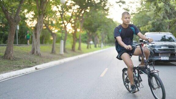 亚洲少年在市中心公园的马路上放松地骑自行车