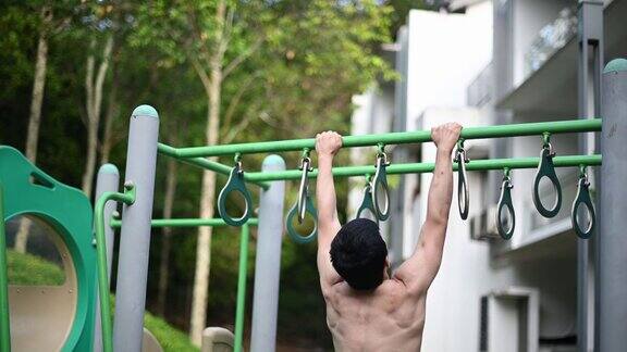 背部的亚洲华人男性运动员赤裸上身肌肉在操场上锻炼