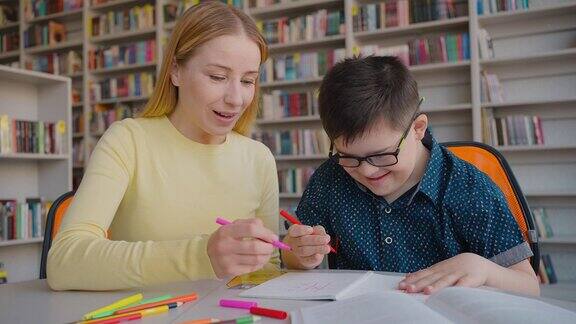 受启发的女教育家在学校图书馆的课上与唐氏综合症男孩玩井字游戏