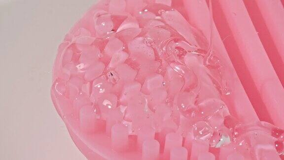 透明化妆品凝胶液与分子泡沫流动在按摩刷微距拍摄液体奶油凝胶化妆品样品纹理气泡