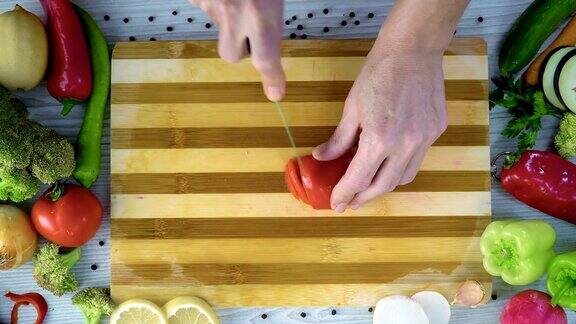 男人在厨房里切蔬菜用慢镜头切西红柿
