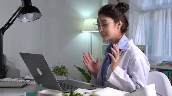 年轻漂亮的亚洲女医生在医务室与病人进行在线会诊年轻女医生用听诊器进行视频通话
