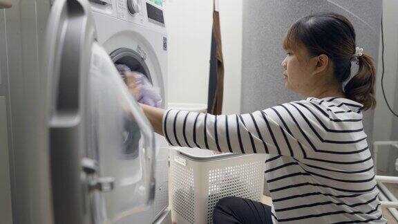 妇女在家里用洗衣机洗衣服