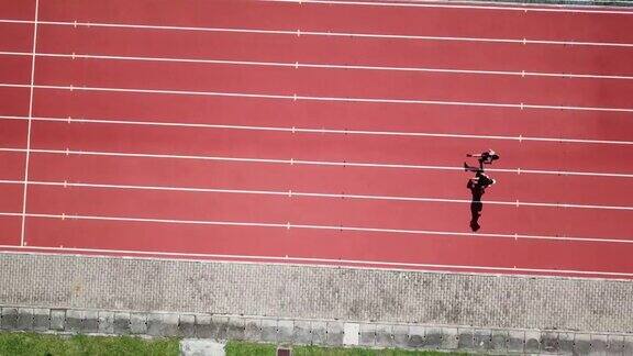 无人机视角体育亚洲华人夫妇运动员上午在田径场跑步