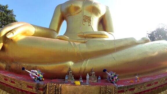 一尊巨大的金色佛像对着泰国寺庙的蓝天芭堤雅