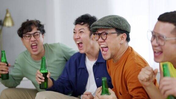 一群亚洲男性朋友一起在家里看电视上的体育比赛