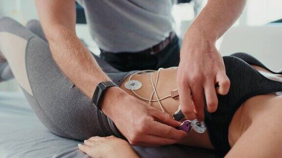 医生在病房给病人使用心电图垫男性医学专家在运动中心做健康测试的特写女运动员进行心脏节律和活动的例行检查