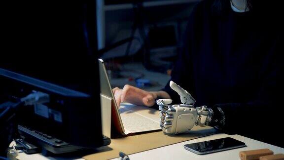 残疾人用仿生手在笔记本电脑上打字金属假肢手工工作