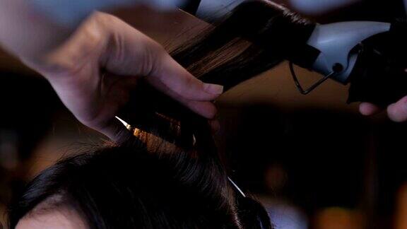 专业的美发师为女性做发型做卷发