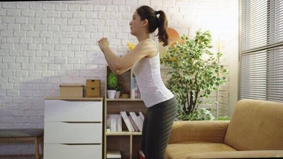 亚洲女性在家里的沙发上锻炼