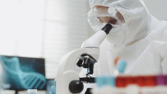 在实验室里使用显微镜的年轻科学家