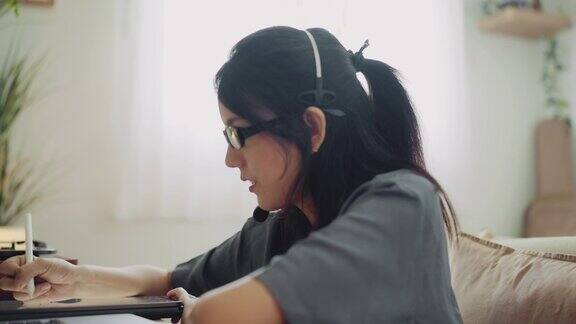 亚洲自由职业者聪明的商业女性休闲穿着使用笔记本电脑在家里工作