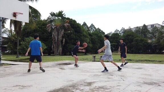 一群十几岁的亚洲华人男孩放学后在篮球场上打篮球和练习篮球