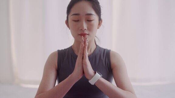 一名年轻的日本女子在瑜伽垫上冥想