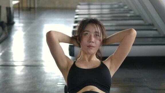 亚洲女性在健身房做仰卧起坐女性在健身馆锻炼身体在健身中心锻炼