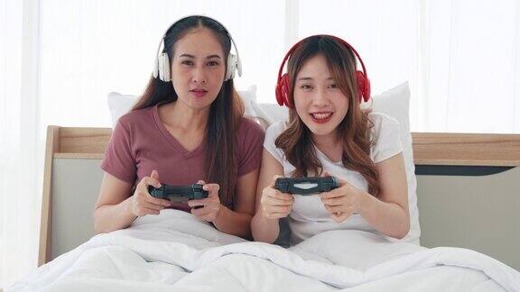 姐妹俩戴着无线耳机拿着操纵杆玩竞技游戏