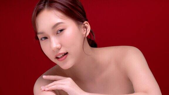 美丽的年轻亚洲女性干净新鲜的皮肤在红色的背景面部护理面部护理美容美容和水疗亚洲女性肖像