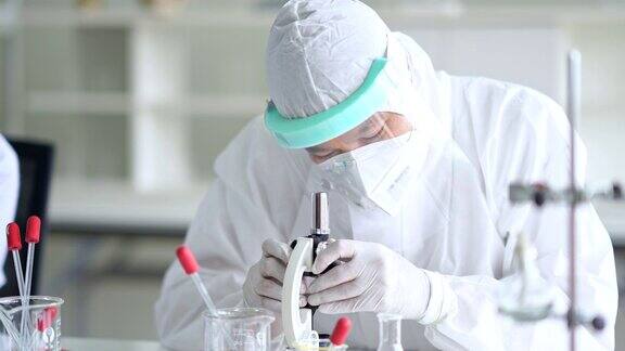 工作人员卫生官员研究疫苗在显微镜实验室的桌子上