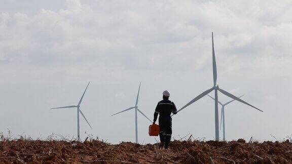 风力涡轮机工程师持有工具箱在风车农场工作可再生能源业务
