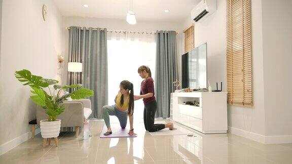 亚洲女性在教练的建议下在家锻炼的场景
