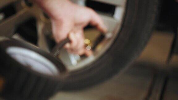汽车维修厂的汽车胎压检查在机械师手中给轮胎充气和检查气压计的细节专业机械师正在汽车维修中心修理汽车