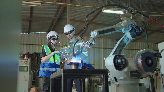 两名工程师男女工作控制机械臂用于检查和测试过程自动化运动的遥控