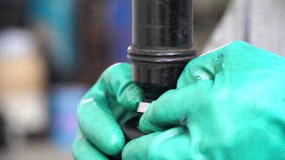 修理工在车库给CV接头橡胶套加润滑油汽车轮轴修理工已检查修理