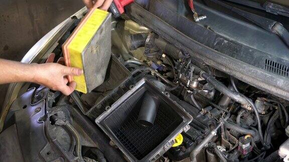机械师把汽车上的空气滤清器卸下来