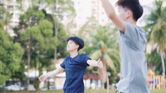 周末早上亚洲华人少年在篮球赛前一起做热身运动