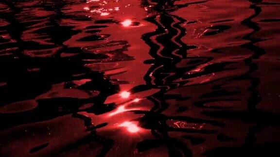散焦涟漪和太阳眩光在红色的血波水模糊单色水背景太阳在波浪上的耀斑慢动作