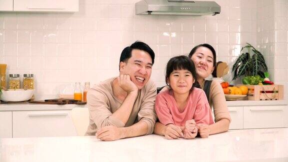 快乐的父母在厨房和他们的女儿聊天