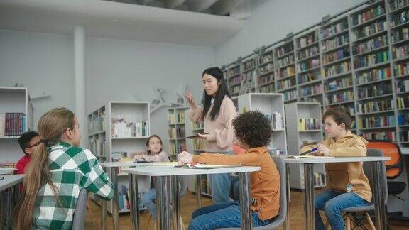 亚洲教师在图书馆向学童讲解