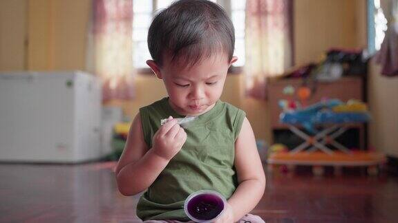 亚洲小男孩吃着甜甜的水果果冻明胶甜点