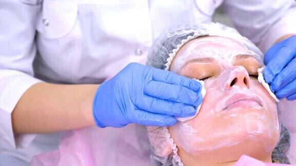 美容师用化妆棉给妇女洗脸脸部特写