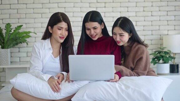 女性在网上做生意一群快乐的亚洲女人坐在床上用笔记本电脑进行视频通话一起在网上销售