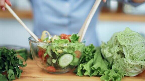 靠近女性的手混合新鲜蔬菜沙拉在碗用RED摄像机拍摄4K