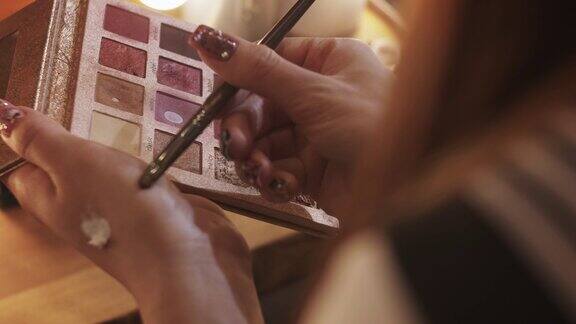 一个女孩正在化妆用画笔在她的手上画上阴影