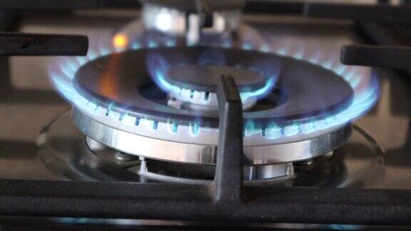 厨房灶头被点燃在一个明亮的蓝色火焰在灶台上烹饪煤气炉被点燃的燃烧器打开