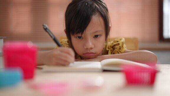 亚洲女学生在看书、做作业和在家网上学习时因近视症状而头痛
