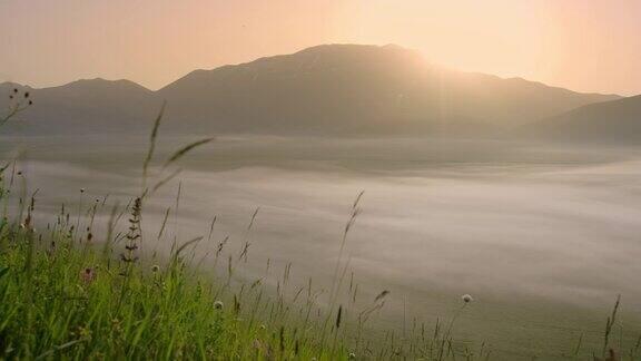 在意大利翁布里亚的卡斯泰鲁西奥宁静的日出从山和雾谷后面升起