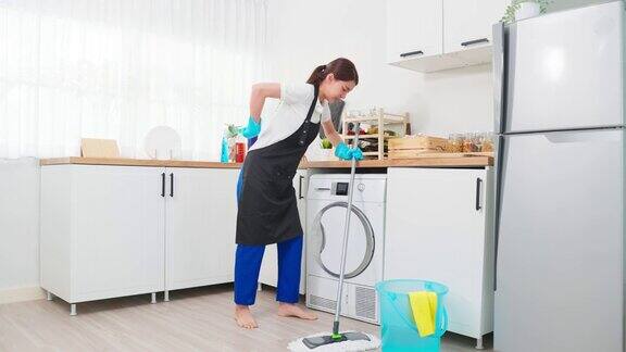 精疲力竭的清洁服务女工在家里打扫厨房美丽的年轻女孩管家清洁工感到累而拖地工作家务或家务在房子