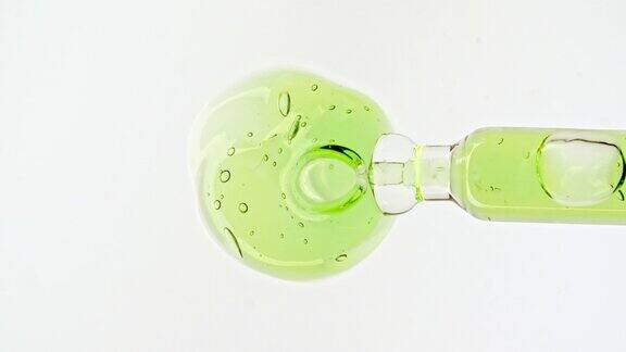 移液管与透明绿色化妆品凝胶液血清与分子气泡油在白色背景微距镜头的天然有机化妆品药品生产特写慢动作