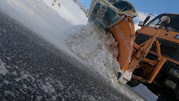 冬季暴风雪过后扫雪车轮胎在山路上清理道路以便车辆通行慢动作